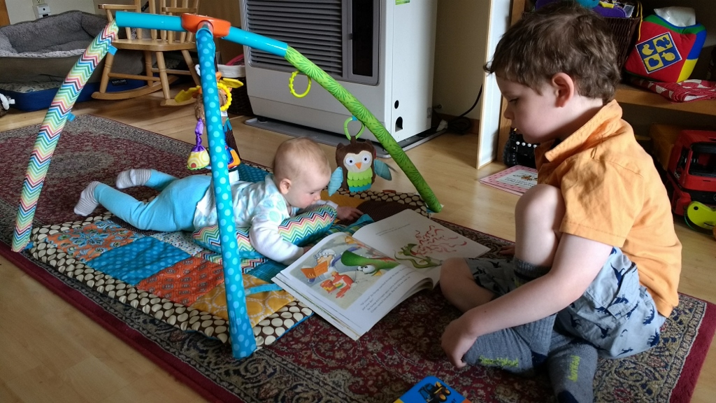 A child reads to an infant