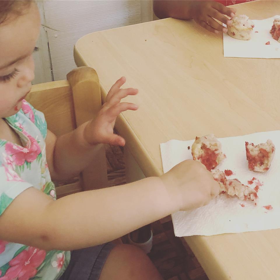 A child eats a berry muffin