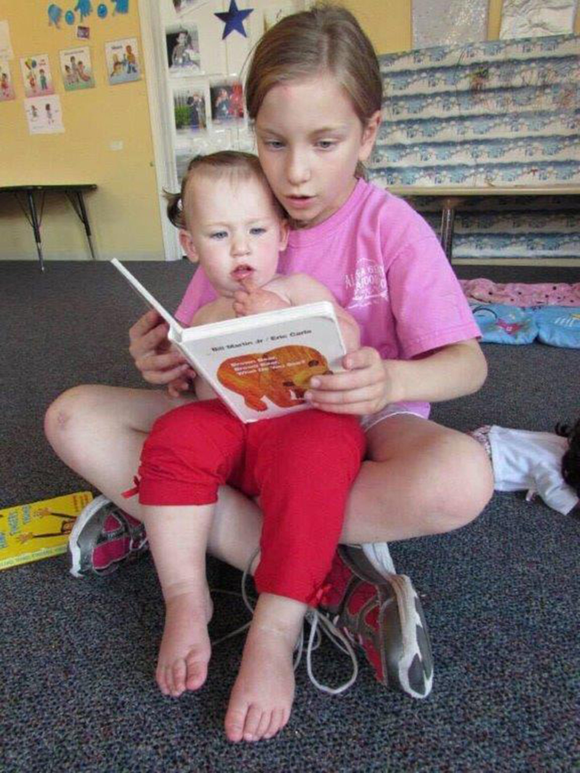 A child reads to an infant