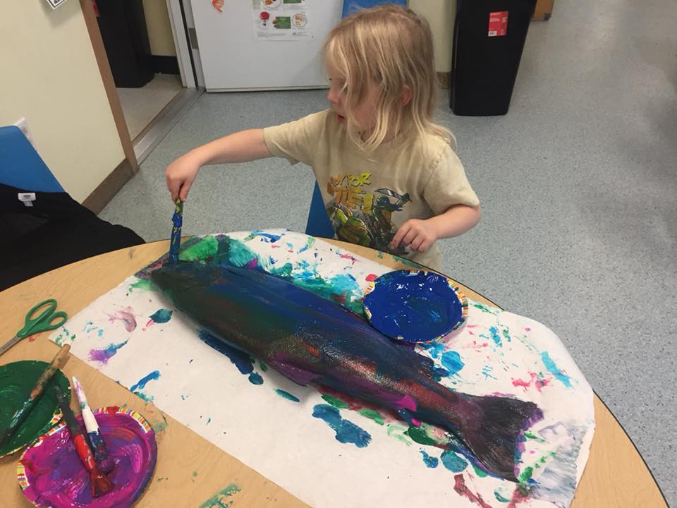 A child makes a fish print with paint